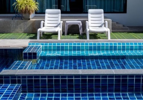 imgi_43_couple-white-sunbeds-green-glass-swimming-pool-with-floating-bench-seat-sitting-zone-with-clean-clear-water-nobody-