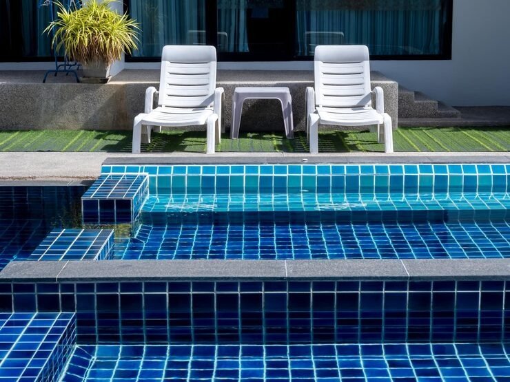 imgi_43_couple-white-sunbeds-green-glass-swimming-pool-with-floating-bench-seat-sitting-zone-with-clean-clear-water-nobody-